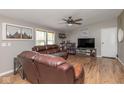 The living room features wood-look flooring, cozy leather seating, a ceiling fan, and natural light at 1683 W County Road 300 S, Danville, IN 46122