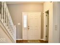Bright entryway boasts wood floors, a white front door with glass insert, and white trim at 1831 Brook Crossing Way, Indianapolis, IN 46229