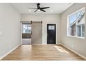 Open living room with wood floors, a ceiling fan, and sliding barn door at 202 Mckim Ave, Indianapolis, IN 46201