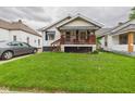 Quaint home with inviting covered porch, complemented by lush green lawn and mature landscaping at 2314 Walnut St, Anderson, IN 46016