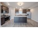 Bright kitchen featuring stainless appliances, an island, and gray wood flooring at 2628 Lamar Dr, Whitestown, IN 46075