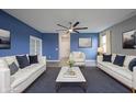 Living room with white sofas, blue pillows, coffee table, artwork, and ceiling fan at 2628 Lamar Dr, Whitestown, IN 46075