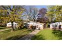 Charming ranch-style home nestled among mature trees with a well-maintained front lawn at 268 S Grant Ave, Indianapolis, IN 46201
