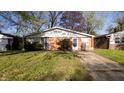 A quaint ranch style house with brick and vinyl siding, surrounded by green lawns at 268 S Grant Ave, Indianapolis, IN 46201