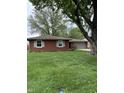 Beautiful one story home with mature trees, brick facade, and attached garage at 2935 Flintwood Dr, Columbus, IN 47203