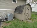 A storage shed sits alongside the home's exterior, adjacent to the AC unit at 3426 Ireland Dr, Indianapolis, IN 46235