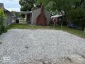 View of gravel backyard featuring a covered patio and lawn area at 357 N 18Th Ave, Beech Grove, IN 46107