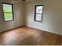 Sunlit bedroom with refinished hardwood flooring and black-trimmed windows at 357 N 18Th Ave, Beech Grove, IN 46107