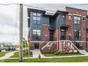 Modern townhome with red brick, gray siding, multiple windows, and landscaped front yard at 401 Jersey St, Westfield, IN 46074