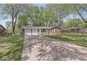 Attractive single-story brick home with attached two-car garage and a large driveway at 4050 Westover Dr, Indianapolis, IN 46268