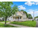 Well-maintained two-story home with a cozy front porch and mature trees at 410 E North St, Greenfield, IN 46140