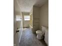Bathroom with vinyl flooring, a window, toilet, and a bathtub at 4109 East 21St St, Indianapolis, IN 46218