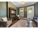 Cozy living room featuring a decorative fireplace, hardwood floors, and serene green walls at 419 N College Ave, Indianapolis, IN 46202