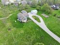 Bird's eye view of a blue home with a large lawn, detached garage, shed, vegetable garden, and gravel driveway at 4284 E County Road 100 S, Avon, IN 46123
