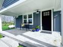 Inviting front porch with a comfortable bench, potted plants, and a black front door, offering a cozy welcome at 4284 E County Road 100 S, Avon, IN 46123