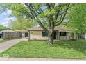 Charming single-story home with a carport, featuring a well-maintained lawn and mature trees at 4432 Brittany Rd, Indianapolis, IN 46222