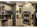 Modern kitchen with stainless steel appliances, ample storage, and warm countertops at 448 Tamarack Ln, Noblesville, IN 46062