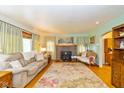 Cozy living room featuring a brick fireplace, hardwood floors, and ample natural light at 4510 Gadsden St, Indianapolis, IN 46241