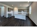 Open-concept kitchen featuring gray cabinets, recessed lighting, an island with sink, and dark hardwood floors at 50 Benfield Dr, Whiteland, IN 46184
