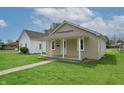 Cozy single-story home with a covered front porch and lush green lawn at 52 N Ross St, Columbus, IN 47201