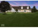 Charming two-story home with a large front yard and inviting porch at dusk at 6086 W 850 S, Edinburgh, IN 46124