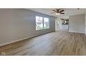 Bright living room with hardwood flooring leading to a bright open-plan kitchen and backyard access at 6420 Greenspire Pl, Indianapolis, IN 46221