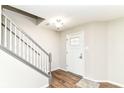 Inviting entryway with new wood flooring, a staircase, and a white front door at 6837 W Burlington Dr, McCordsville, IN 46055