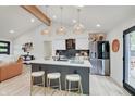 Modern kitchen with stainless steel appliances, island with seating, and wood beam at 8049 Burn Ct, Indianapolis, IN 46217