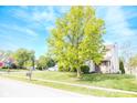 Exterior of a charming home with a manicured lawn, tree, and a brick and siding facade at 9718 Jupiter Pass, Carmel, IN 46032