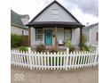 Charming home with a welcoming porch and a well-maintained, inviting white picket fence at 1035 Albany St, Indianapolis, IN 46203