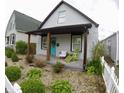 Inviting house with covered front porch, stylish chairs, and lush landscaping in a nicely designed space at 1035 Albany St, Indianapolis, IN 46203
