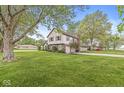 A view of the home highlighting the long driveway and lawn at 1106 Fox Trail W Dr, New Palestine, IN 46163
