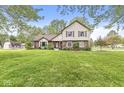 Spacious front yard with mature trees surrounding a charming two-story home at 1106 Fox Trail W Dr, New Palestine, IN 46163