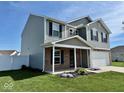 Two-story home with gray siding, brick accents, manicured lawn, and an attached two-car garage at 1112 W Nature Pointe Ln, Muncie, IN 47304