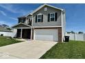 Two-story home with gray siding, brick accents, manicured lawn, and attached two-car garage at 1112 W Nature Pointe Ln, Muncie, IN 47304