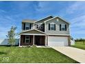 Two-story home with gray siding, brick accents, manicured lawn, and an attached two-car garage at 1112 W Nature Pointe Ln, Muncie, IN 47304