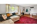 Spacious living room with hardwood flooring, area rug, and comfortable sectional sofa with throw pillows at 1225 N Graham Ave, Indianapolis, IN 46219