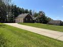 Well-maintained home with an expansive lawn, long driveway, and mature trees at 125 W Chalet Dr, Mooresville, IN 46158