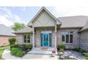 Charming brick home front entrance with a decorative blue door and well-maintained landscaping at 1297 Morningside Dr, Greenfield, IN 46140