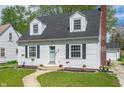 Inviting home with a lush green lawn, quaint landscaping, and a charming pathway leading to the front door at 155 N Franklin Rd, Indianapolis, IN 46219