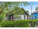 Charming single-story home with brick and green siding, fenced front yard and blue home to right at 1602 Villa Ave, Indianapolis, IN 46203