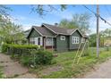 View of home with green wood siding, green shingles, chain link fence and nice yard at 1602 Villa Ave, Indianapolis, IN 46203