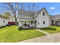 Quaint two-story home featuring a welcoming front porch with swing at 223 Grove St, Greenfield, IN 46140
