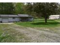 Gray home features a gravel driveway leading up to the house, complemented by a large green tree at 3282 S Conservation Club Rd, Morgantown, IN 46160