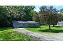Charming home featuring a well-maintained lawn and a gravel driveway, surrounded by mature trees at 3282 S Conservation Club Rd, Morgantown, IN 46160