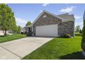 This lovely home boasts a brick facade, two-car garage, and a neatly kept lawn at 3311 Stoddard Pl, Indianapolis, IN 46217