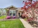 Inviting home featuring blooming pink azaleas, stone accents, and a well-maintained lawn, creating a welcoming curb appeal at 3480 Limelight Ln, Whitestown, IN 46075