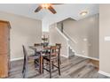 Open dining area with wood floors, a ceiling fan, and a staircase leading to the upper level at 401 Shadetree Ln, Sheridan, IN 46069