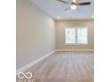 Spacious bedroom with carpet floors, neutral walls, a ceiling fan, and bright light from a large window at 403 Fox Ridge Ct, Shelbyville, IN 46176