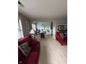 Inviting living room with a red sofa, light-filled with an open floor plan leading into the dining area at 4402 Mountbatten Ct, Indianapolis, IN 46254